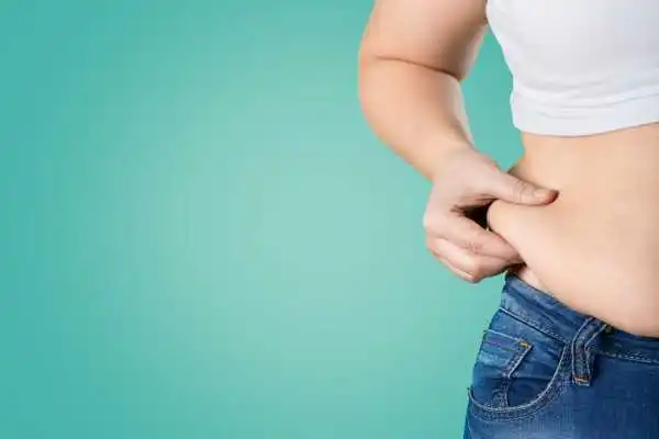 Image of woman pinching her love handles to show weight gain Smethwick